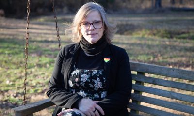 Woman sitting on wooden swing bench outdoors