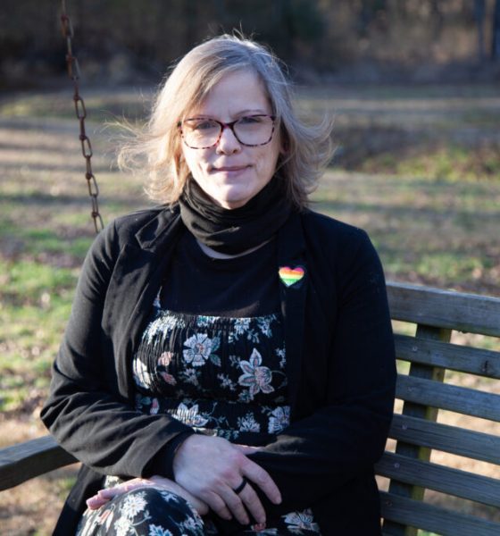 Woman sitting on wooden swing bench outdoors