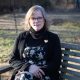 Woman sitting on wooden swing bench outdoors