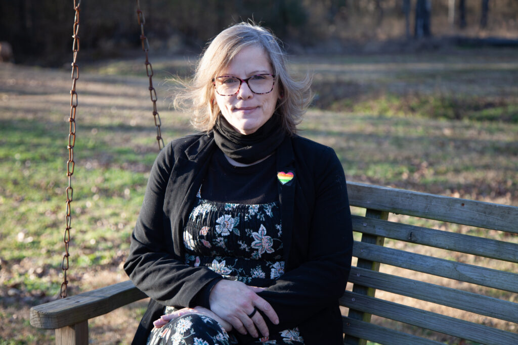 Woman sitting on wooden swing bench outdoors