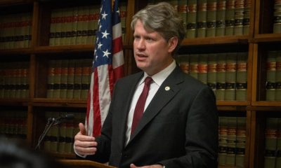 Man speaking at podium with American flag