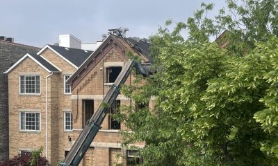 Crane lifting materials onto brick house roof