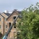 Crane lifting materials onto brick house roof