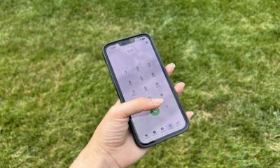 Hand holding smartphone dialing 911 outdoors