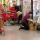 Employee stocking frozen food in grocery store aisle