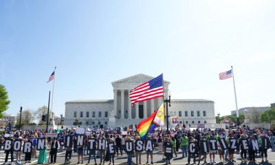 Protesters outside Supreme Court holding citizenship signs