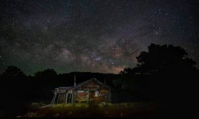 Rustic cabin under Milky Way night sky