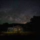 Rustic cabin under Milky Way night sky
