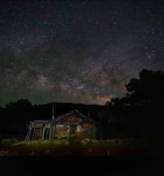 Milky Way over rustic cabin at night