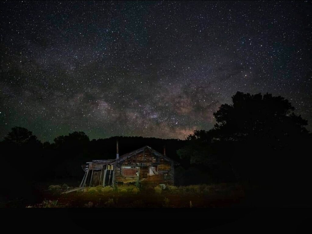 Milky Way over rustic cabin at night