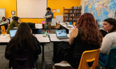Teacher holding baby in classroom with students