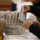 Person sorting mail-in ballots in postal box