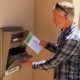 Man placing envelope into outdoor drop box