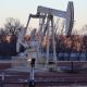 Oil pumpjack operating at dusk in rural field