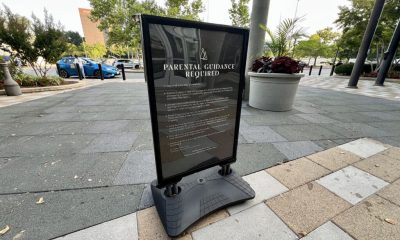 Parental guidance required sign on sidewalk