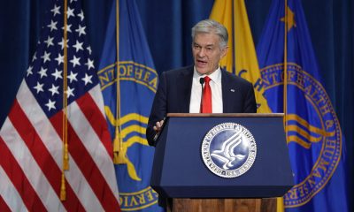 Man speaking at HHS podium with US flags