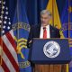 Man speaking at HHS podium with US flags