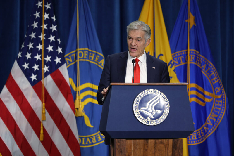 Man speaking at HHS podium with US flags