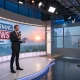 News anchor delivering morning broadcast in studio