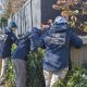 FBI agents in jackets examining a bush near a fence, highlighting crime investigation efforts. — FBI crime report 2025