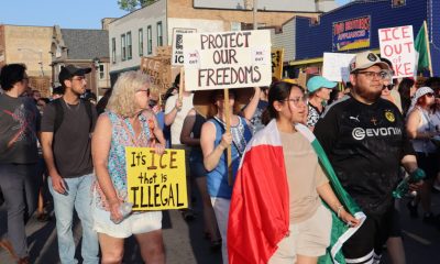Protesters march holding signs against ICE and immigration enforcement, with a Me — federal law enforcement grants lawsuit
