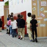 Children walking in a school hallway, passing by colorful educational posters and lock — federal education funding waivers