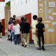 Children walking in a school hallway, passing by colorful educational posters and lock — federal education funding waivers