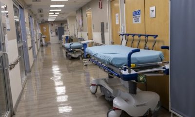 Empty hospital hallway with stretchers and medical equipment, reflecting a quiet — private equity healthcare acquisitions