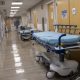Empty hospital hallway with stretchers and medical equipment, reflecting a quiet — private equity healthcare acquisitions