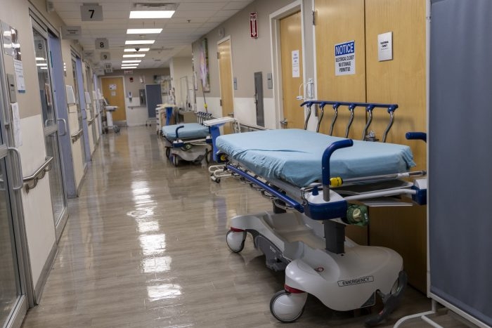 Empty hospital hallway with stretchers and medical equipment, reflecting a quiet — private equity healthcare acquisitions
