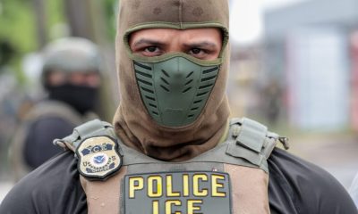 An ICE officer in tactical gear with a mask and police insignia, focused expre — immigration enforcement houses of worship