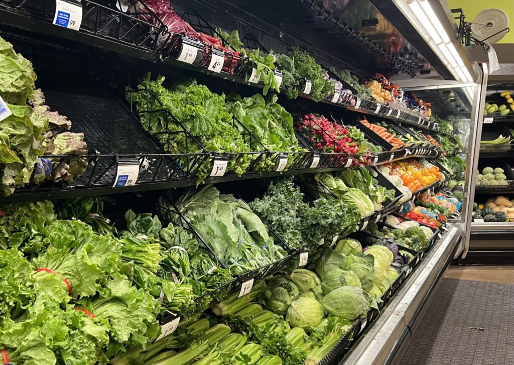 A grocery store produce section filled with various types of lettuce and greens, highlighting multistate food recalls.
