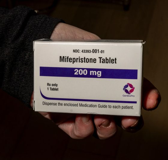 A hand holding a box of mifepristone tablets, labeled 200 mg, with instructions for patients. — mifepristone lawsuit texas