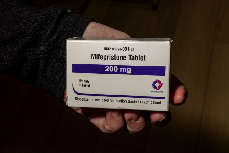 A hand holding a box of mifepristone tablets, labeled 200 mg, with instructions for patients. — mifepristone lawsuit texas