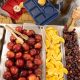 A school cafeteria display with trays of apples, oranges, grapes, and desserts, highlighting — SNAP cuts free school meals