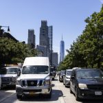 Busy New York City street with traffic and skyscrapers in the background, including One W — New York climate Superfund law