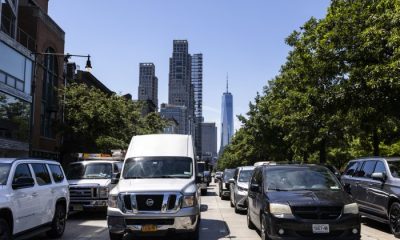 Busy New York City street with traffic and skyscrapers in the background, including One W — New York climate Superfund law