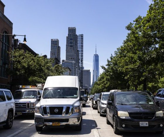 Busy New York City street with traffic and skyscrapers in the background, including One W — New York climate Superfund law