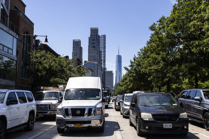Busy New York City street with traffic and skyscrapers in the background, including One W — New York climate Superfund law
