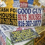 Colorful signs advertising cash home buying services, stacked together, with phone n — Real Estate Wholesaling Regulations