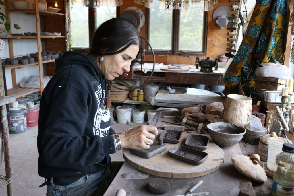 Artist working on pottery in a rustic studio filled with tools and materials. — Alpha-Gal Syndrome Kentucky