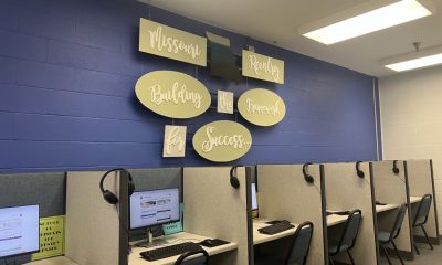 A room with computer workstations and a wall sign reading 'Missouri Reentry Framework for — women on parole mental health
