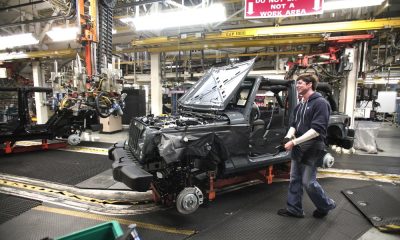 An auto worker in a manufacturing facility assembling a vehicle amid machinery and equip — Trump Canada trade war midterms