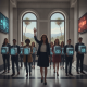 Group of professionals in business attire holding digital icons, symbolizing support for National Promotoras Month.