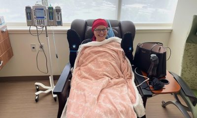 A smiling woman in a hospital chair wrapped in a blanket, undergoing treatm — cancer vaccine clinical trial North Carolina