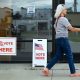A woman walks past polling signs that say 'Vote Here' outside a voting location. — can trump send troops to polling places