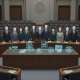 A group of lawmakers standing behind a table with digital icons representin — National Suicide Prevention Month resolution
