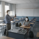 A teacher confiscating cellphones from a student in a classroom under the Indiana School Cellphone Ban.