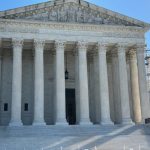 The U.S. Supreme Court building with its iconic columns and steps, under a clear b — Supreme Court mail in voting decision