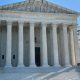 The U.S. Supreme Court building with its iconic columns and steps, under a clear b — Supreme Court mail in voting decision